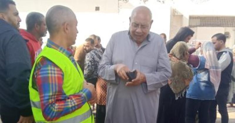 متطوعون يساعدون كبار السن امام اللجان