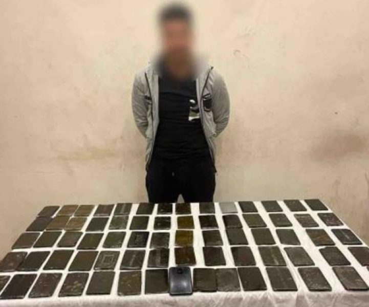 المتهم وأمامه المضبوطات