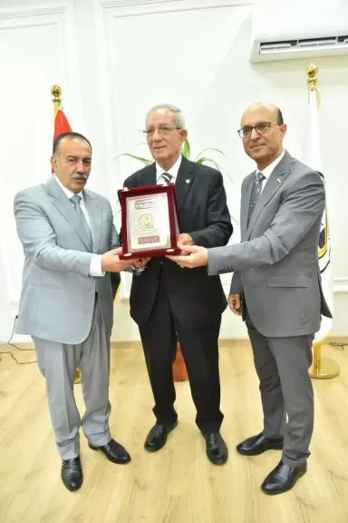 رئيس جامعة أسيوط يهدي الدرع تكريم
