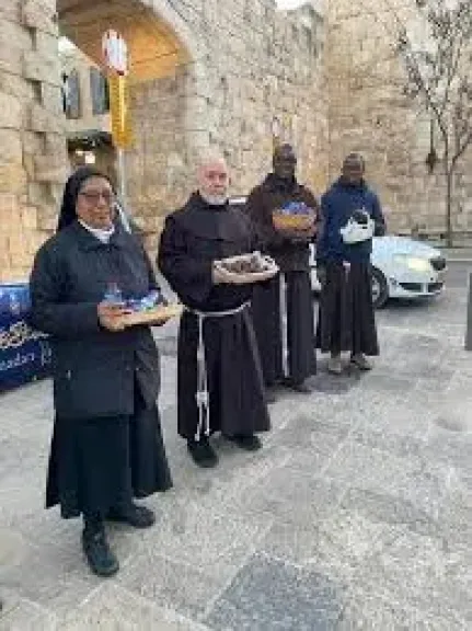 رهبان كنيسة القيامة يوزعون التمر على الصائمين