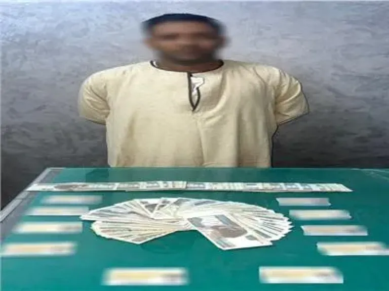 المتهم وامامه المبالغ والبطاقات الشخصية المضبوطة