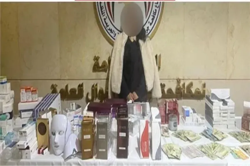 المتهمة وأمامها المضبوطات